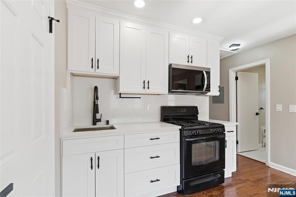 293 North Center Street, Unit 2 Orange, NJ 07050 - Photo 12 of 25 a kitchen with cabinets stainless steel appliances and wooden floor