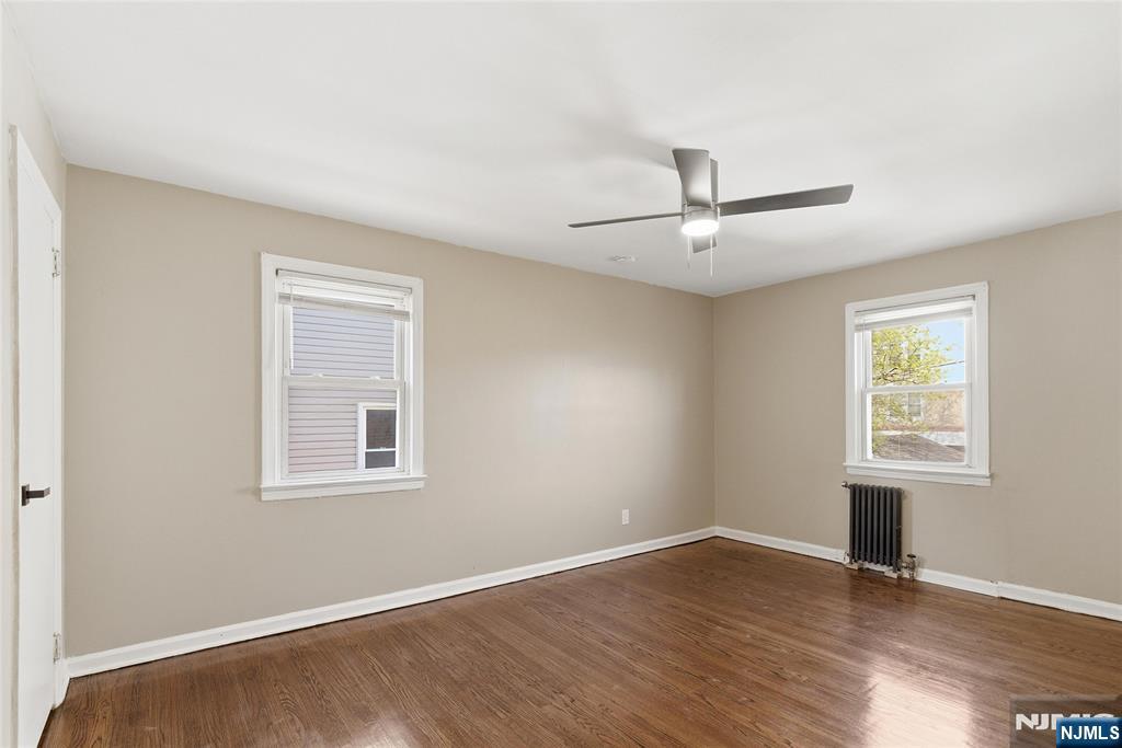 293 North Center Street, Unit 2 Orange, NJ 07050 - Photo 16 of 25 an empty room with wooden floor and windows