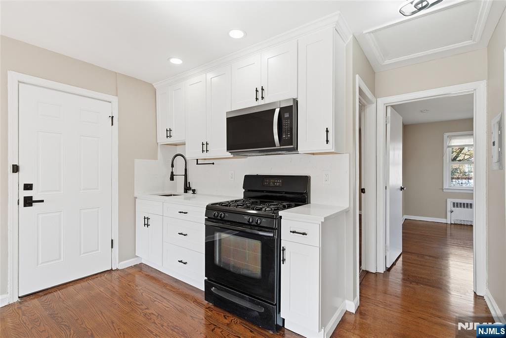 293 North Center Street, Unit 2 Orange, NJ 07050 - Photo 21 of 25 a kitchen with stainless steel appliances a stove microwave and cabinets
