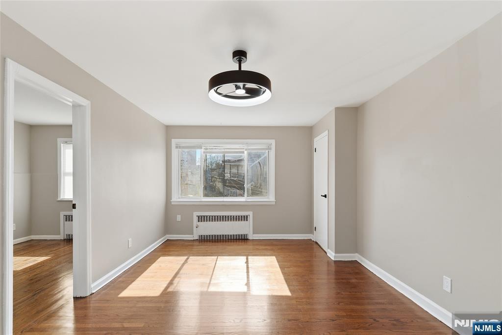 293 North Center Street, Unit 2 Orange, NJ 07050 - Photo 7 of 25 a view of an empty room with wooden floor and a window
