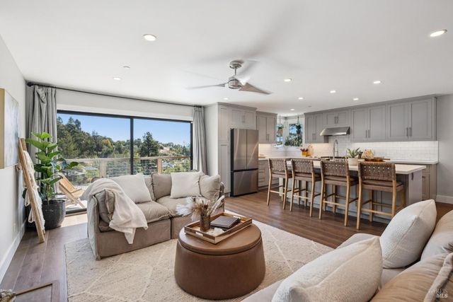 a living room with furniture potted plant and a large window