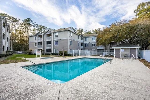 a view of house with swimming pool and yard
