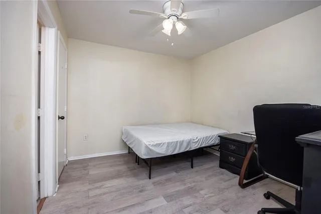 a bedroom with a bed and a ceiling fan