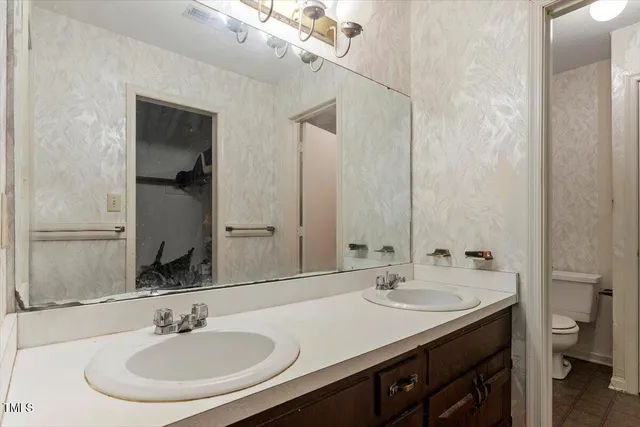 a bathroom with a sink double vanity and a toilet