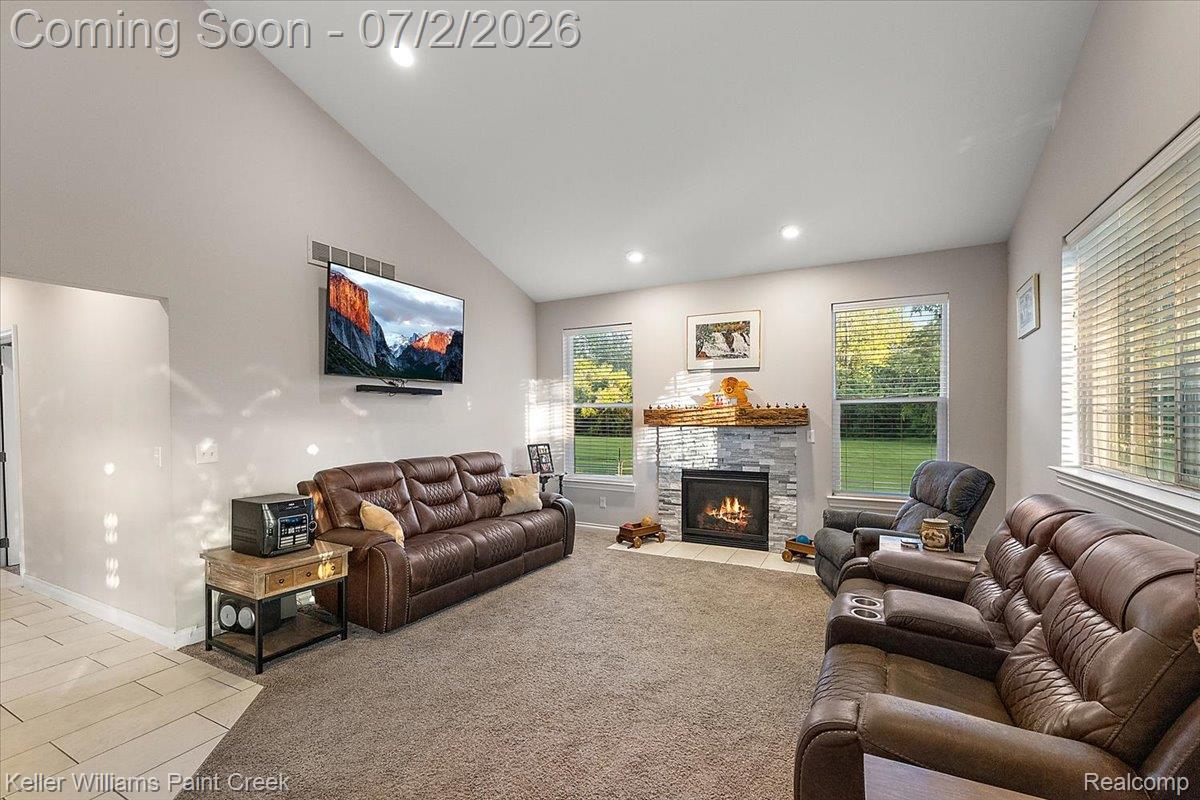 54230 Card Road Macomb, MI 48042 - Photo 44 of 73 Vaulted ceiling living area featuring a stone-surround fireplace with wood mantel, recessed lighting, and multiple windows
