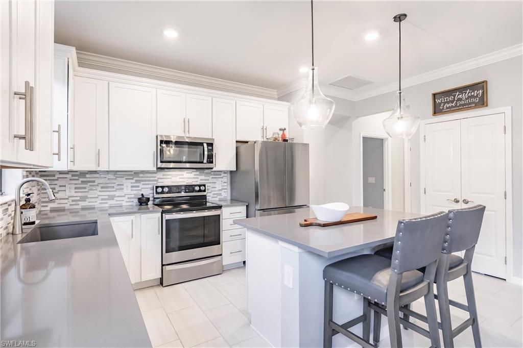 16637 Rolling Rock Boulevard Alva, FL 33920 - Photo 19 of 46 a kitchen with kitchen island granite countertop a sink cabinets and stainless steel appliances
