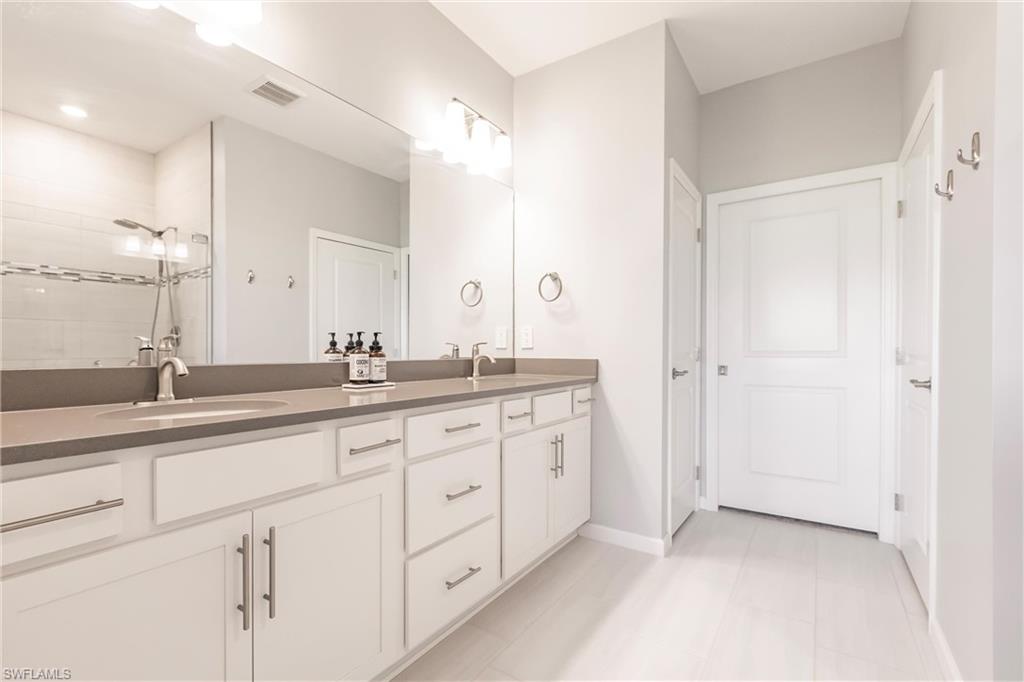 16637 Rolling Rock Boulevard Alva, FL 33920 - Photo 28 of 46 a bathroom with a double vanity sink and a mirror