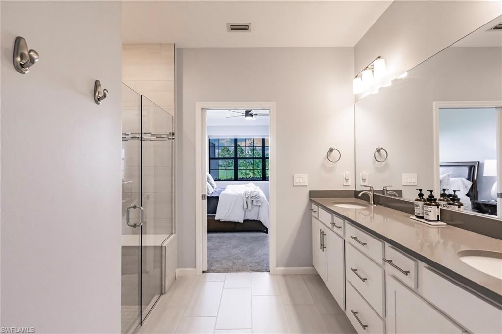 16637 Rolling Rock Boulevard Alva, FL 33920 - Photo 31 of 46 a spacious bathroom with a double vanity sink a mirror and a shower