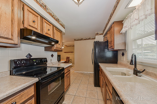 16 Pembrooke Road Montgomery, IL 60538 - Photo 4 of 16 a kitchen with stainless steel appliances granite countertop a sink stove and refrigerator