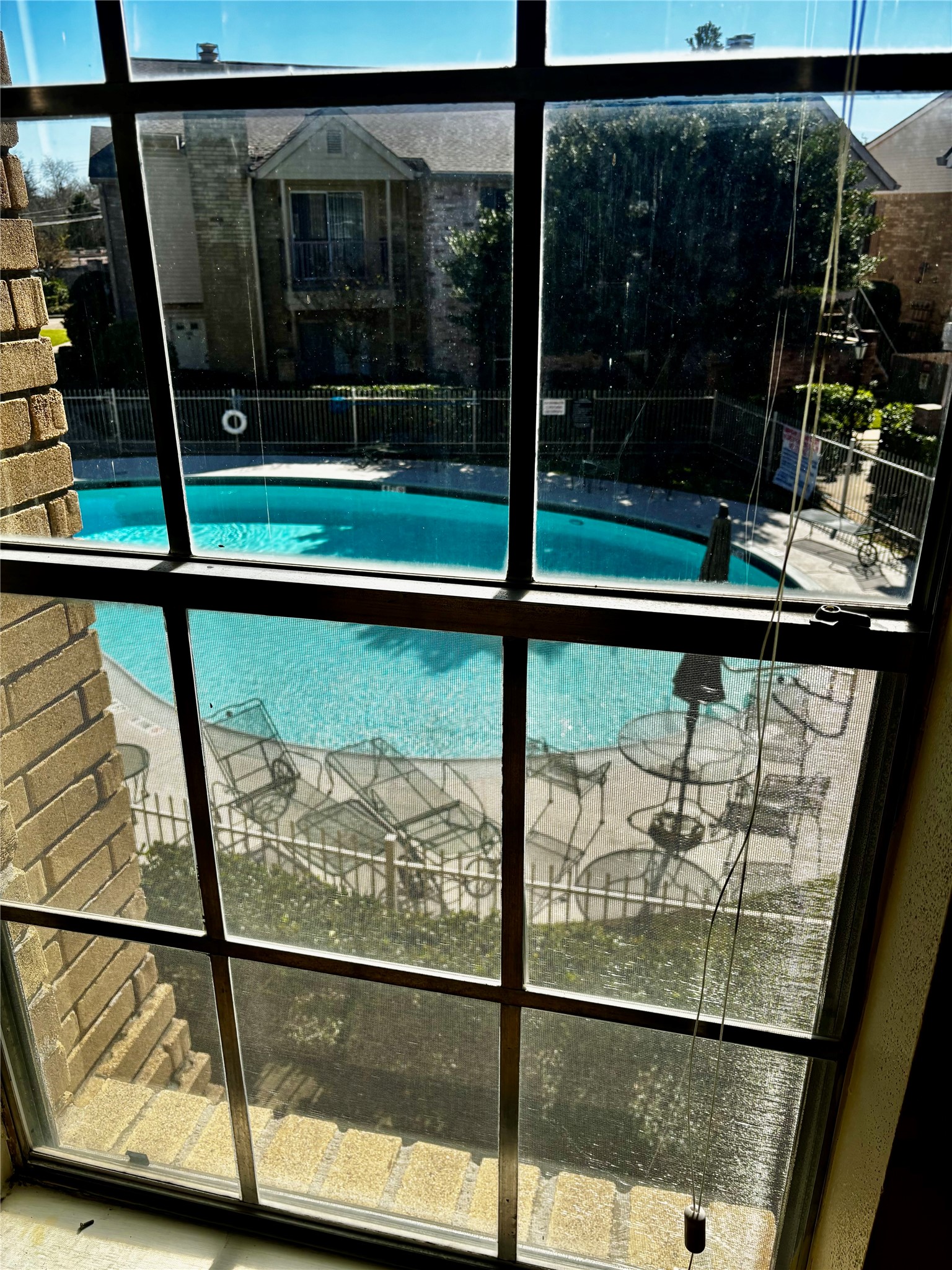 3100 Jeanetta Street, Unit 1004 Houston, TX 77063 - Photo 36 of 42 A look from the upper-level window confirms the property's premier placement, offering a bird's-eye view of the pool and the community's lush landscaping.