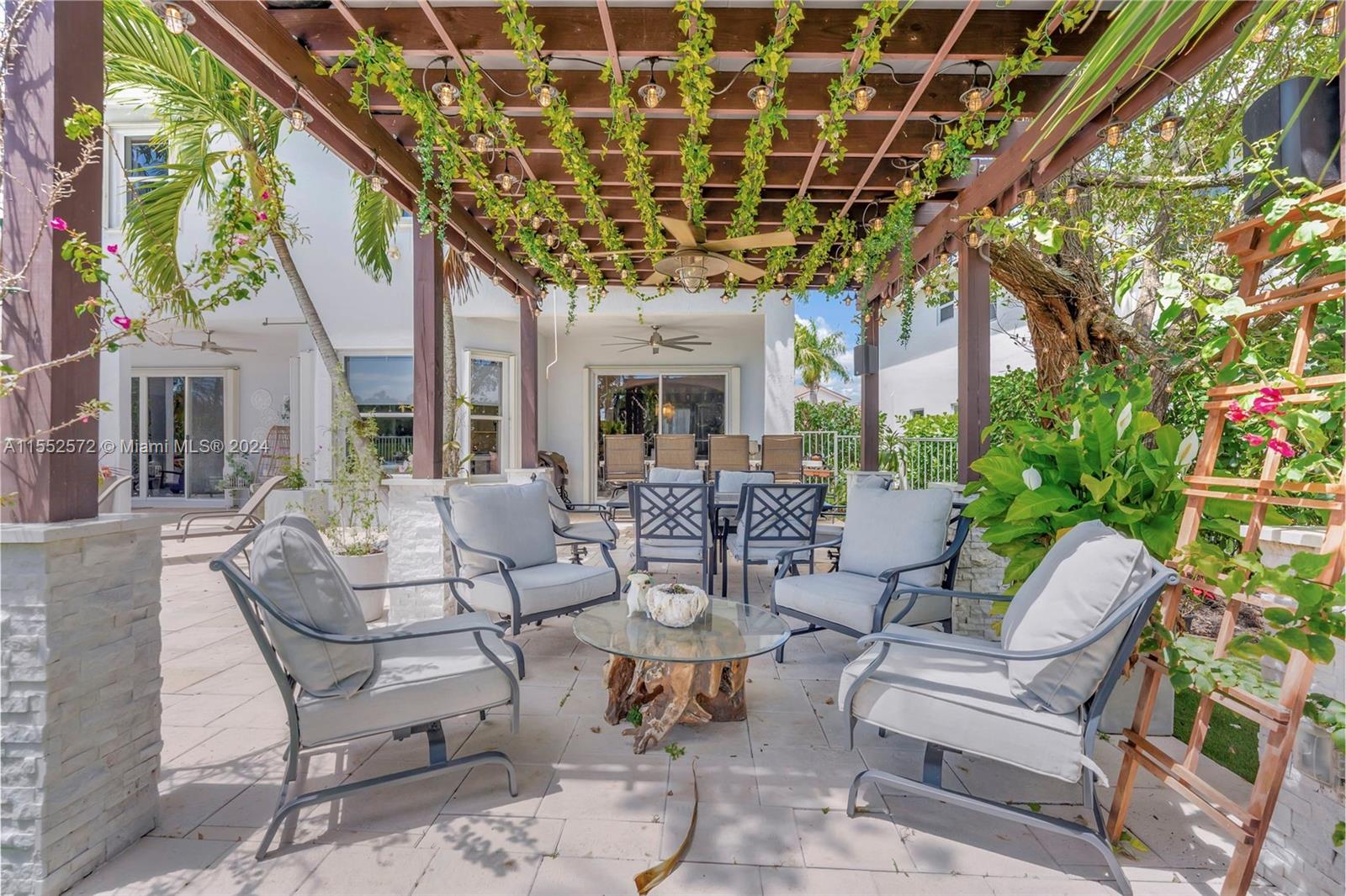 809 Regal Cove Road Weston, FL 33327 - Photo 15 of 70 a view of a patio with a table and chairs and potted plants