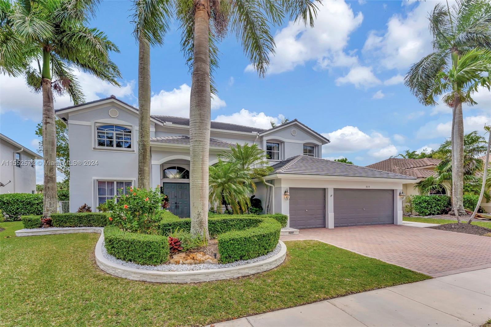 809 Regal Cove Road Weston, FL 33327 - Photo 2 of 70 a front view of a house with a garden and trees