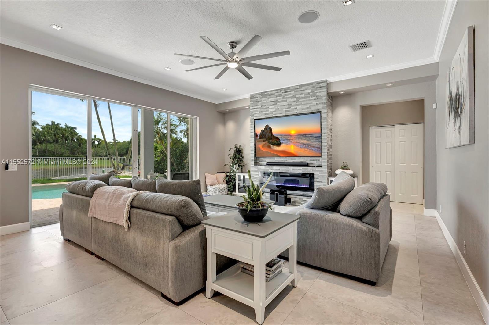 809 Regal Cove Road Weston, FL 33327 - Photo 53 of 70 a living room with furniture ceiling fan and a large window