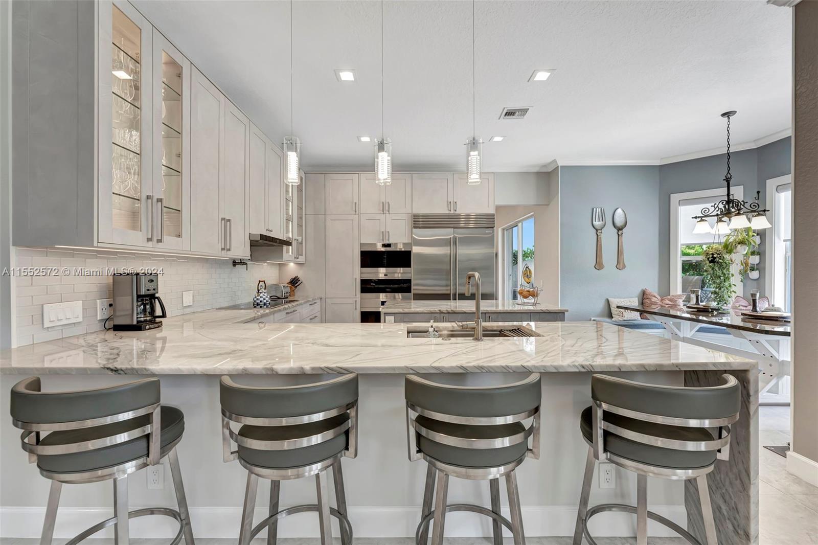 809 Regal Cove Road Weston, FL 33327 - Photo 57 of 70 a kitchen with kitchen island granite countertop a sink and white cabinets