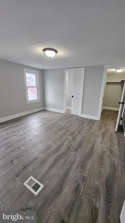 a view of a livingroom with wooden floor and a window