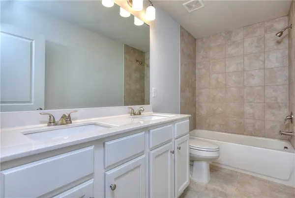 a bathroom with a granite countertop sink a toilet and a bathtub