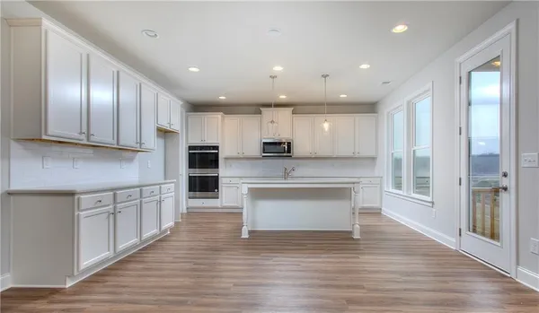 a large kitchen with a large counter top space stainless steel appliances and cabinets