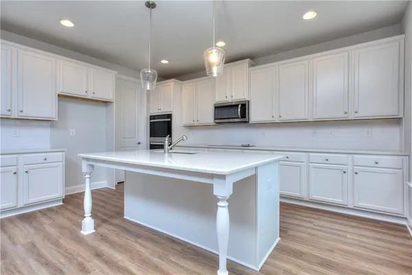 a kitchen with kitchen island granite countertop a sink appliances and cabinets