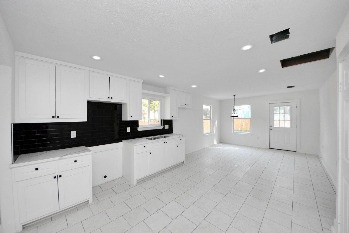 27090 Diamond C Splendora, TX 77372 - Photo 3 of 20 a kitchen with granite countertop white cabinets and black appliances