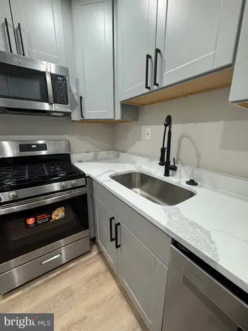 a kitchen with stainless steel appliances granite countertop a sink a stove and microwave