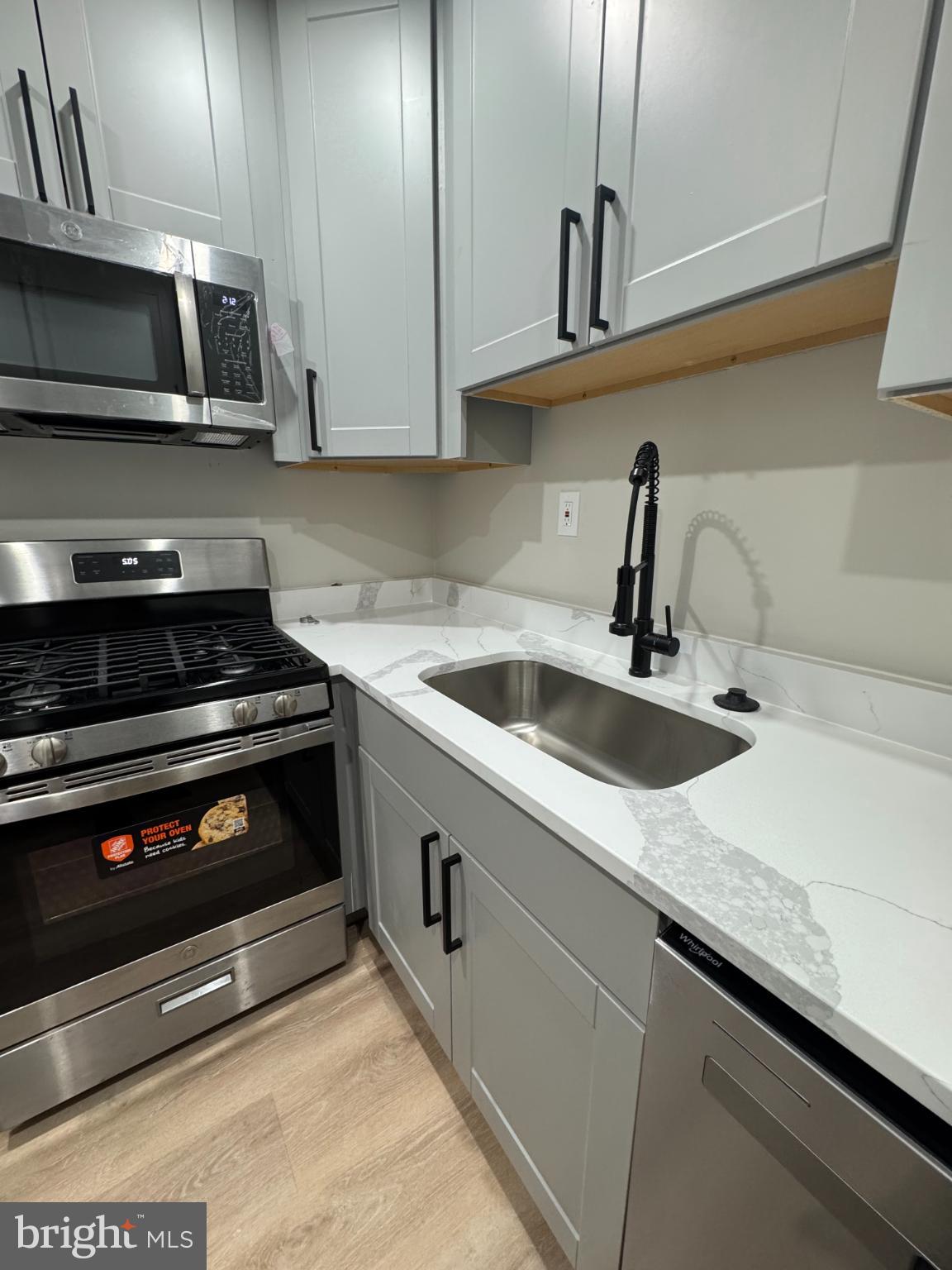3801 Swann Road, Unit 303 Suitland, MD 20746 - Photo 6 of 19 a kitchen with stainless steel appliances granite countertop a sink a stove and microwave