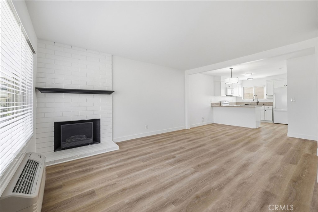1722 Mitchell, Unit 152 Tustin, CA 92780 - Photo 4 of 25 a room with a fireplace and wooden floor