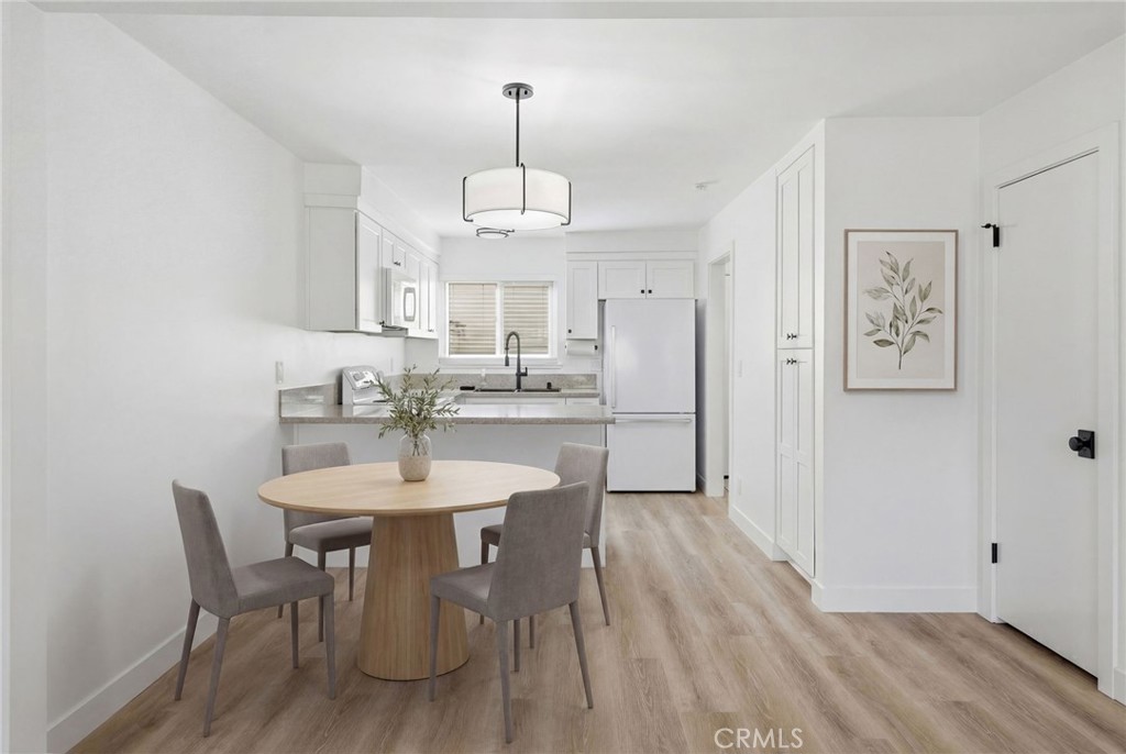 1722 Mitchell, Unit 152 Tustin, CA 92780 - Photo 6 of 25 a view of a dining room with furniture wooden floor kitchen and a chandelier