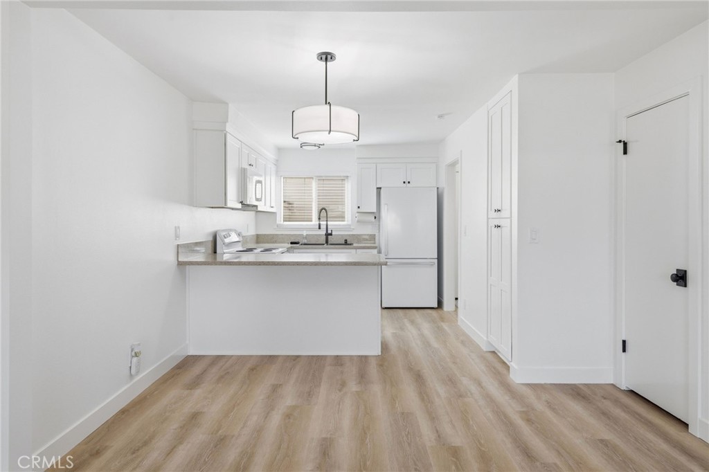 1722 Mitchell, Unit 152 Tustin, CA 92780 - Photo 7 of 25 a view of kitchen cabinets and wooden floor