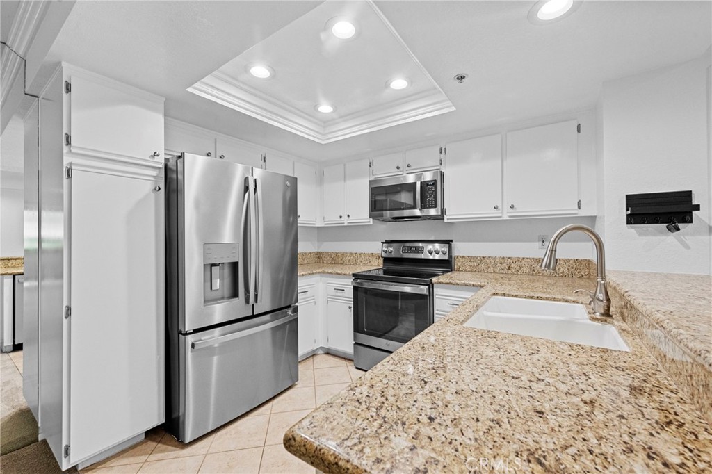 215 South Cross Creek Road, Unit L Orange, CA 92869 - Photo 7 of 50 a kitchen with granite countertop a refrigerator and a sink