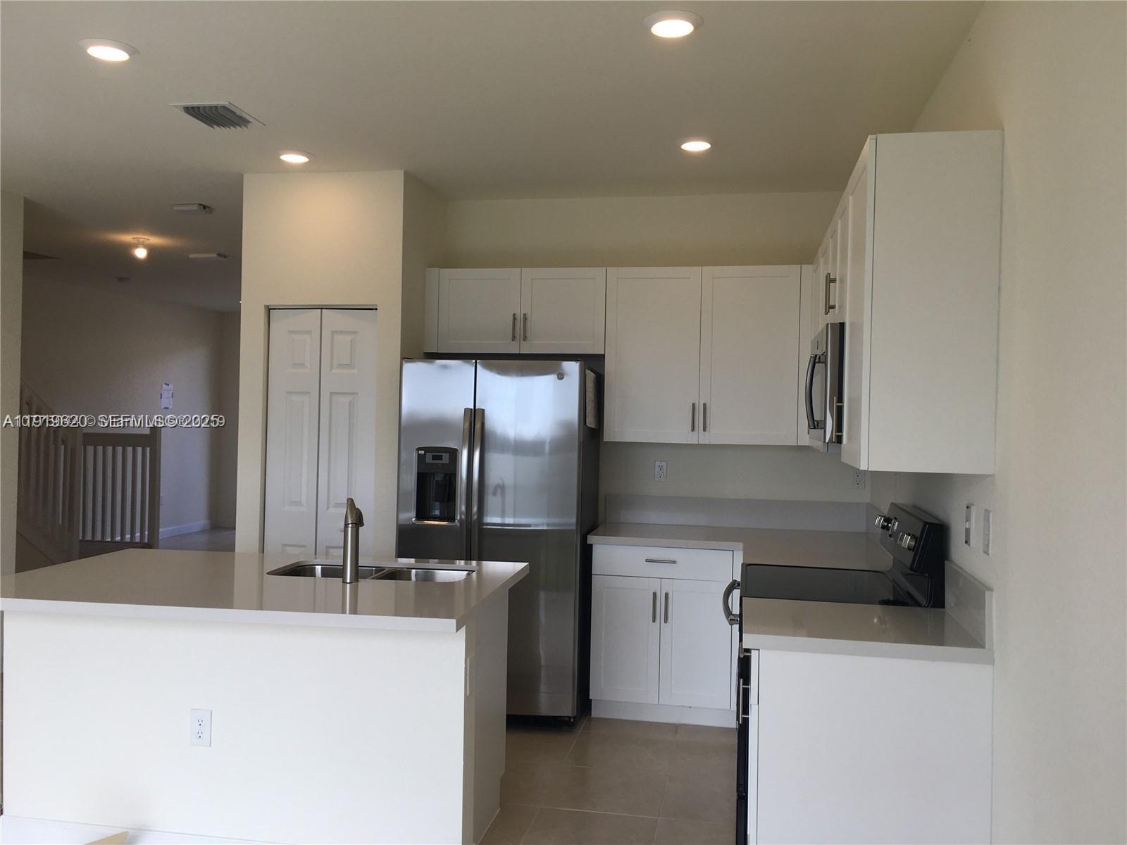 3388 West 100th Terrace Hialeah, FL 33018 - Photo 2 of 13 a kitchen with cabinets and stainless steel appliances