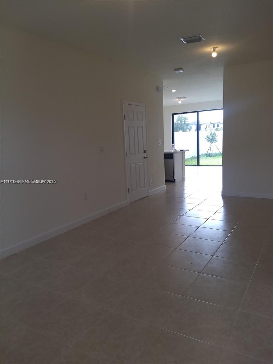 3388 West 100th Terrace Hialeah, FL 33018 - Photo 4 of 13 wooden floor in an empty room with a window