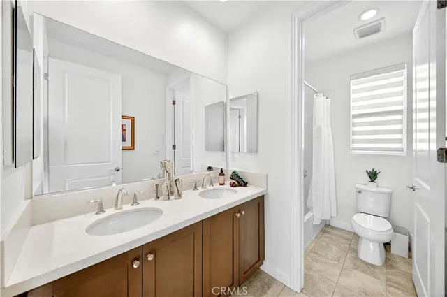 a bathroom with a sink double vanity and a toilet