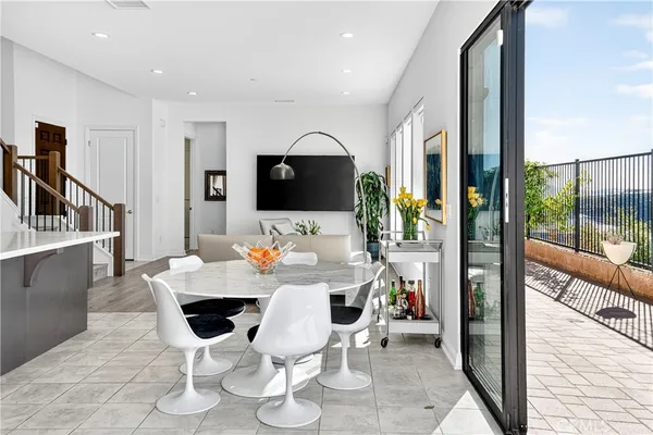 a view of a dining room with furniture one side kitchen view and wooden floor