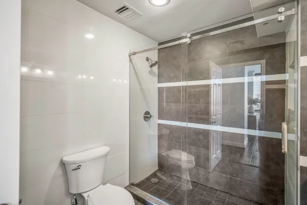 a bathroom with a granite countertop sink a mirror and a shower