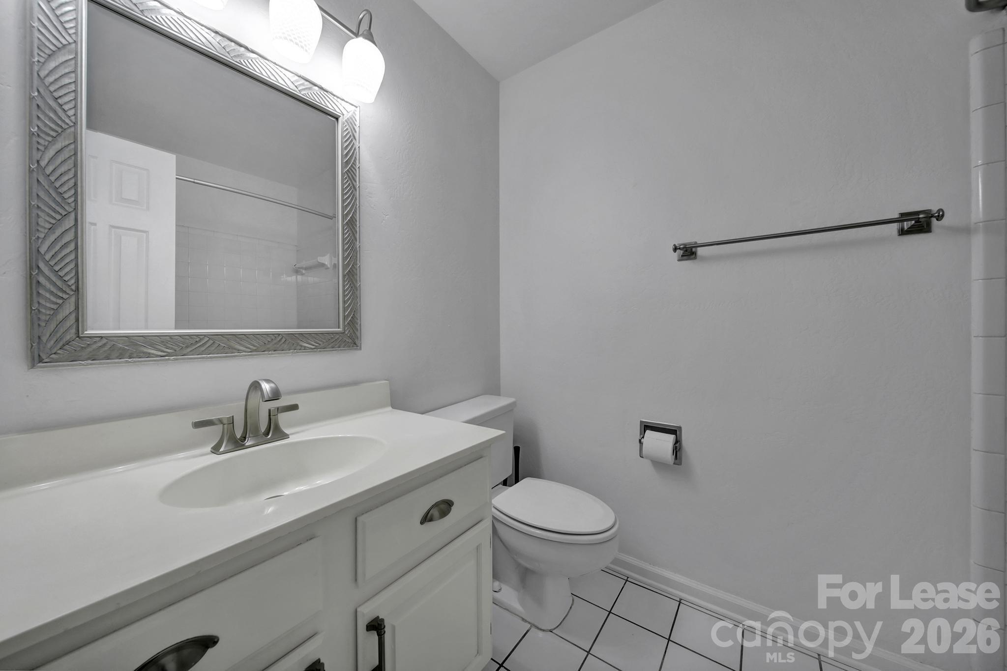 5007 Sharon Road, Unit E Charlotte, NC 28210 - Photo 15 of 24 a bathroom with a sink mirror vanity and toilet