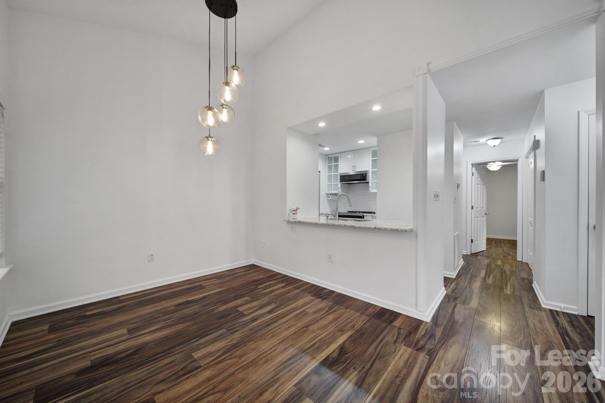 5007 Sharon Road, Unit E Charlotte, NC 28210 - Photo 5 of 24 a view of a room with wooden floor and a ceiling fan