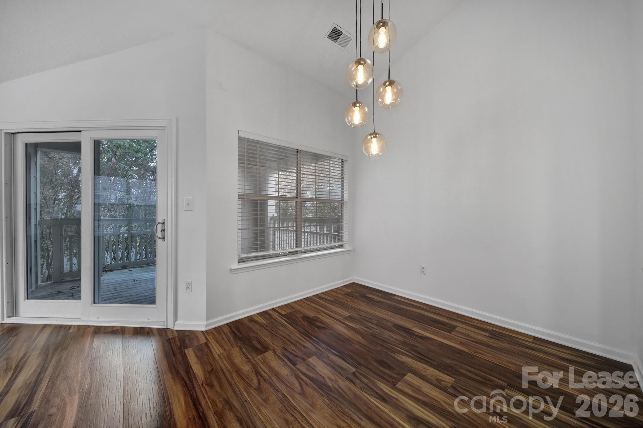 5007 Sharon Road, Unit E Charlotte, NC 28210 - Photo 6 of 24 wooden floor in an empty room with a window