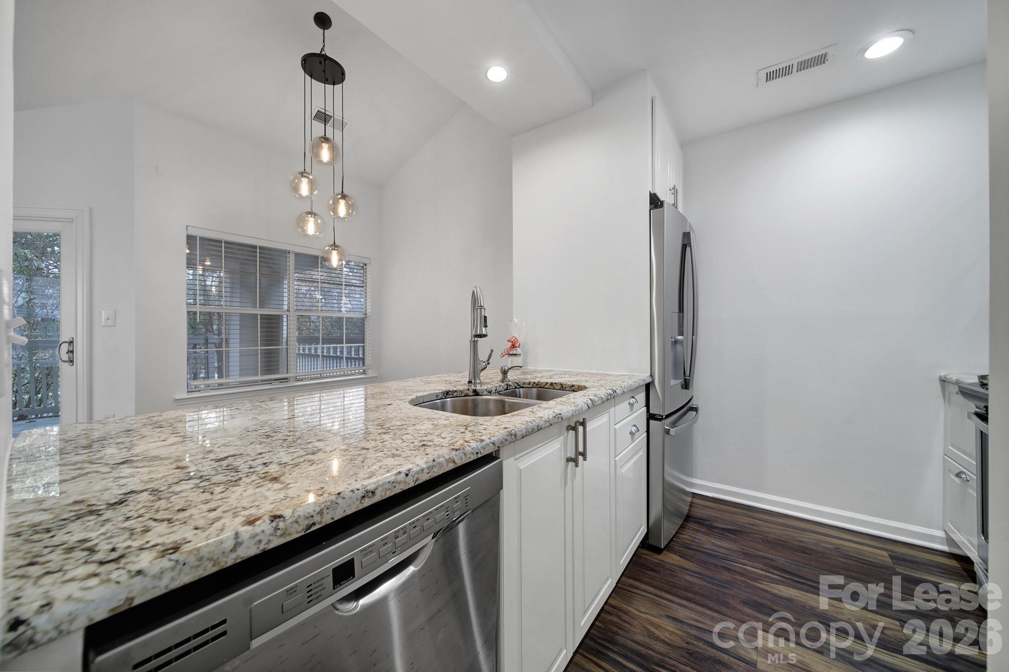 5007 Sharon Road, Unit E Charlotte, NC 28210 - Photo 9 of 24 a kitchen with stainless steel appliances granite countertop a sink and a refrigerator
