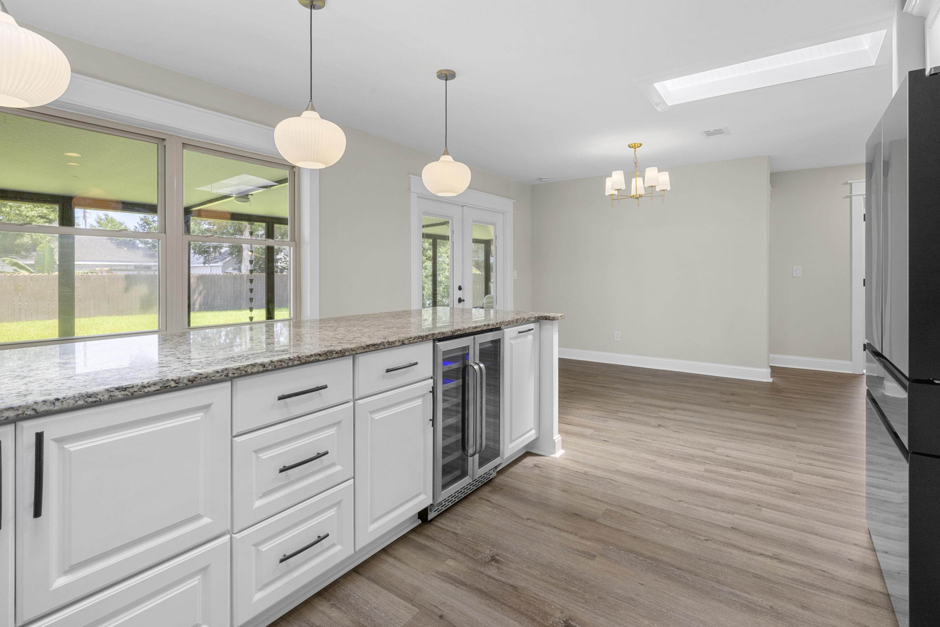 308 Spring Lane Destin, FL 32541 - Photo 11 of 47 a large kitchen with stainless steel appliances granite countertop a oven a stove and a wooden floors