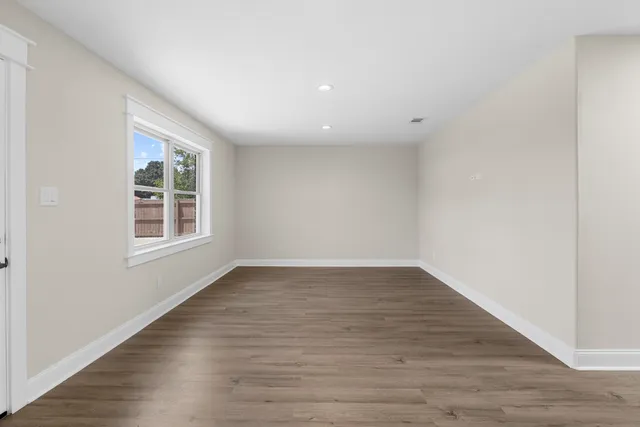 wooden floor in an empty room with a window