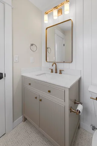 a bathroom with a sink a toilet and a mirror