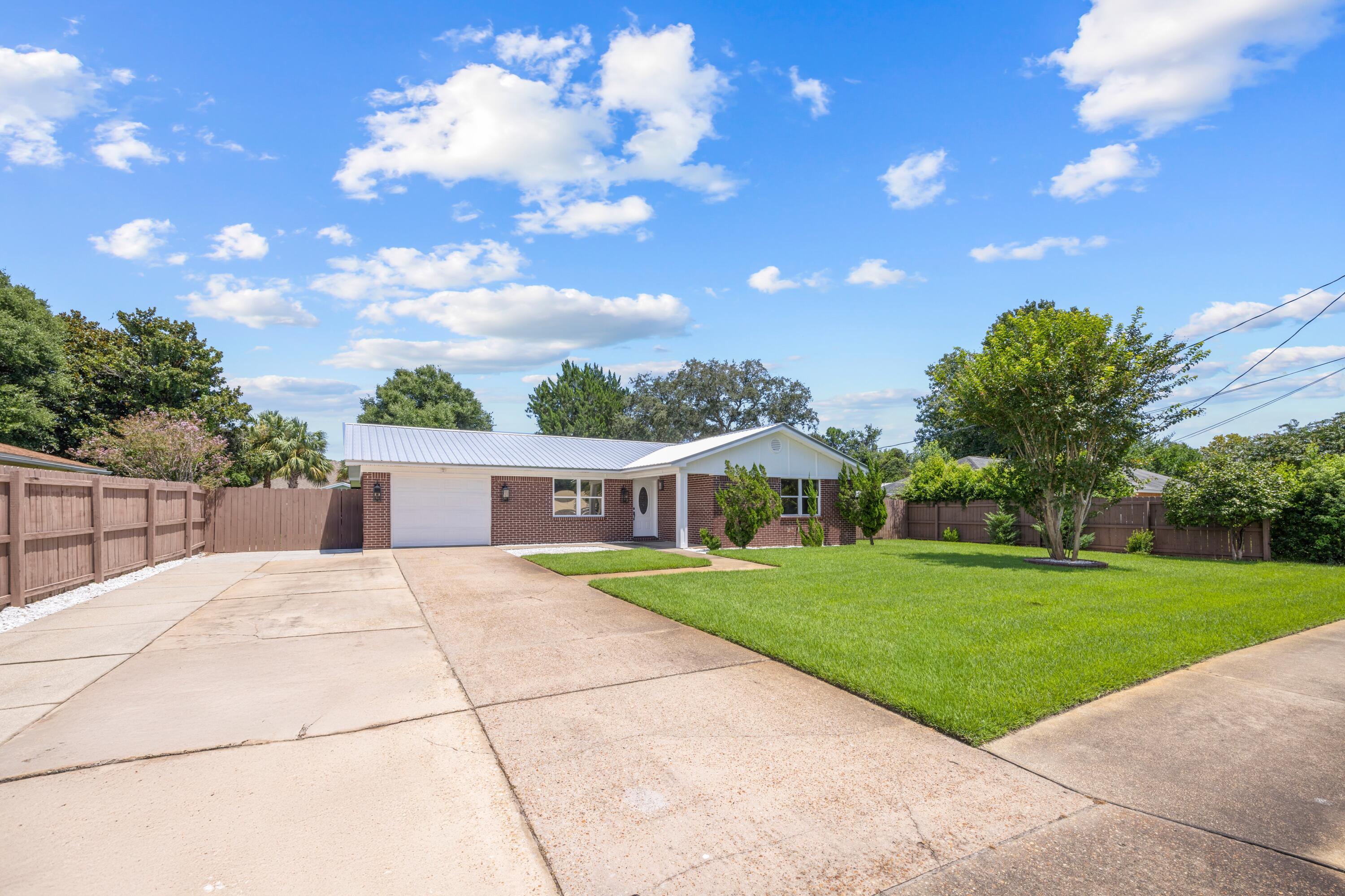 308 Spring Lane Destin, FL 32541 - Photo 2 of 47 a front view of a house with a garden and yard