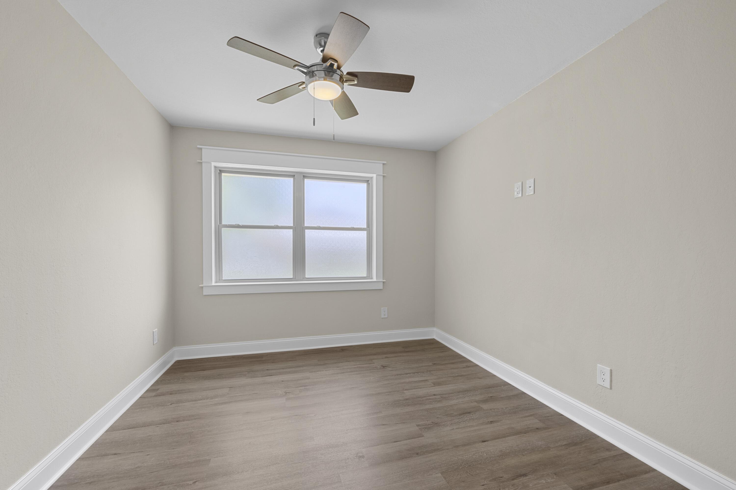308 Spring Lane Destin, FL 32541 - Photo 26 of 47 an empty room with wooden floor and windows