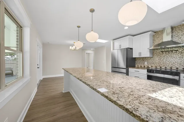 a kitchen with a refrigerator cabinets and wooden floor