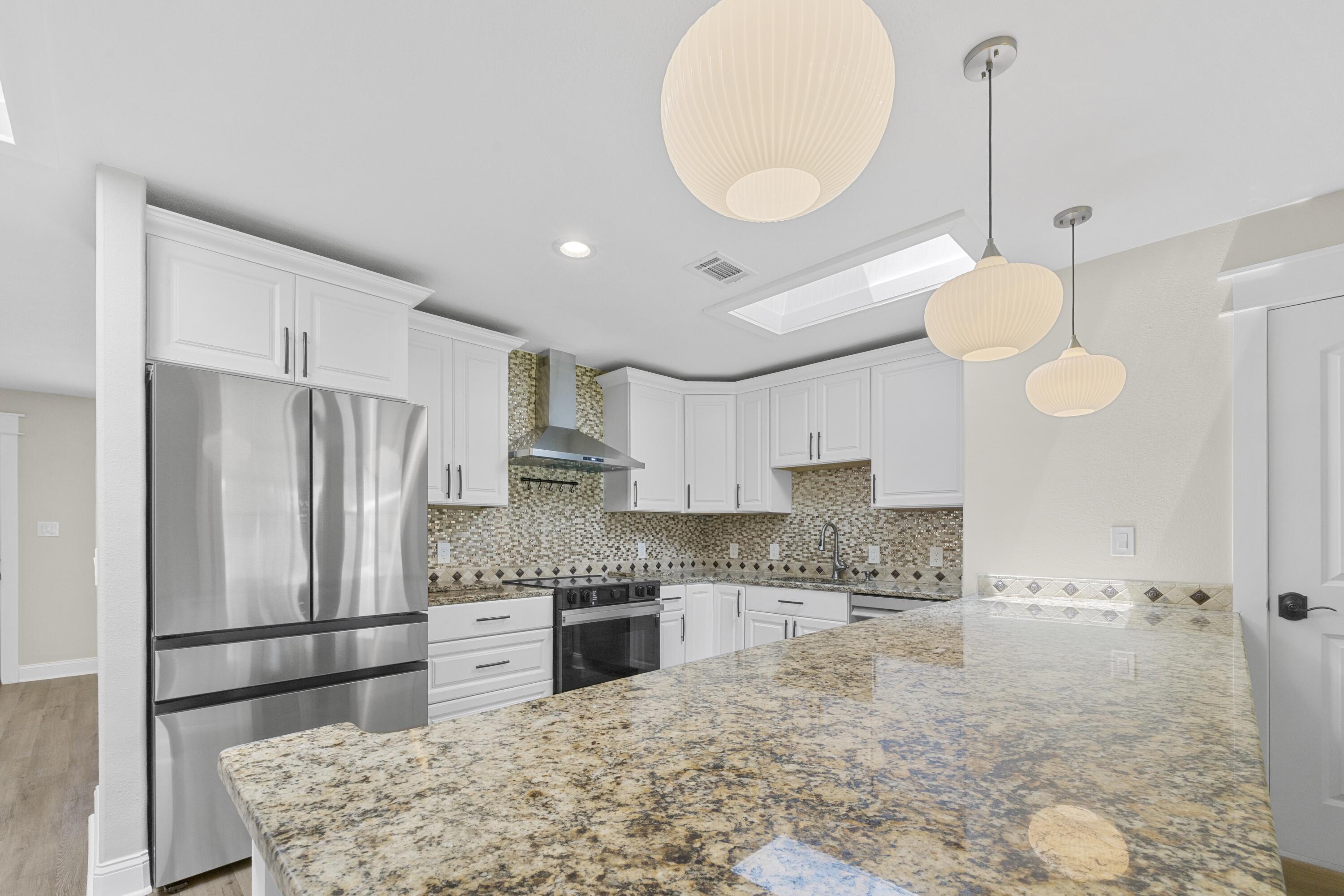 308 Spring Lane Destin, FL 32541 - Photo 9 of 47 a kitchen with stainless steel appliances granite countertop a sink a stove refrigerator and cabinets