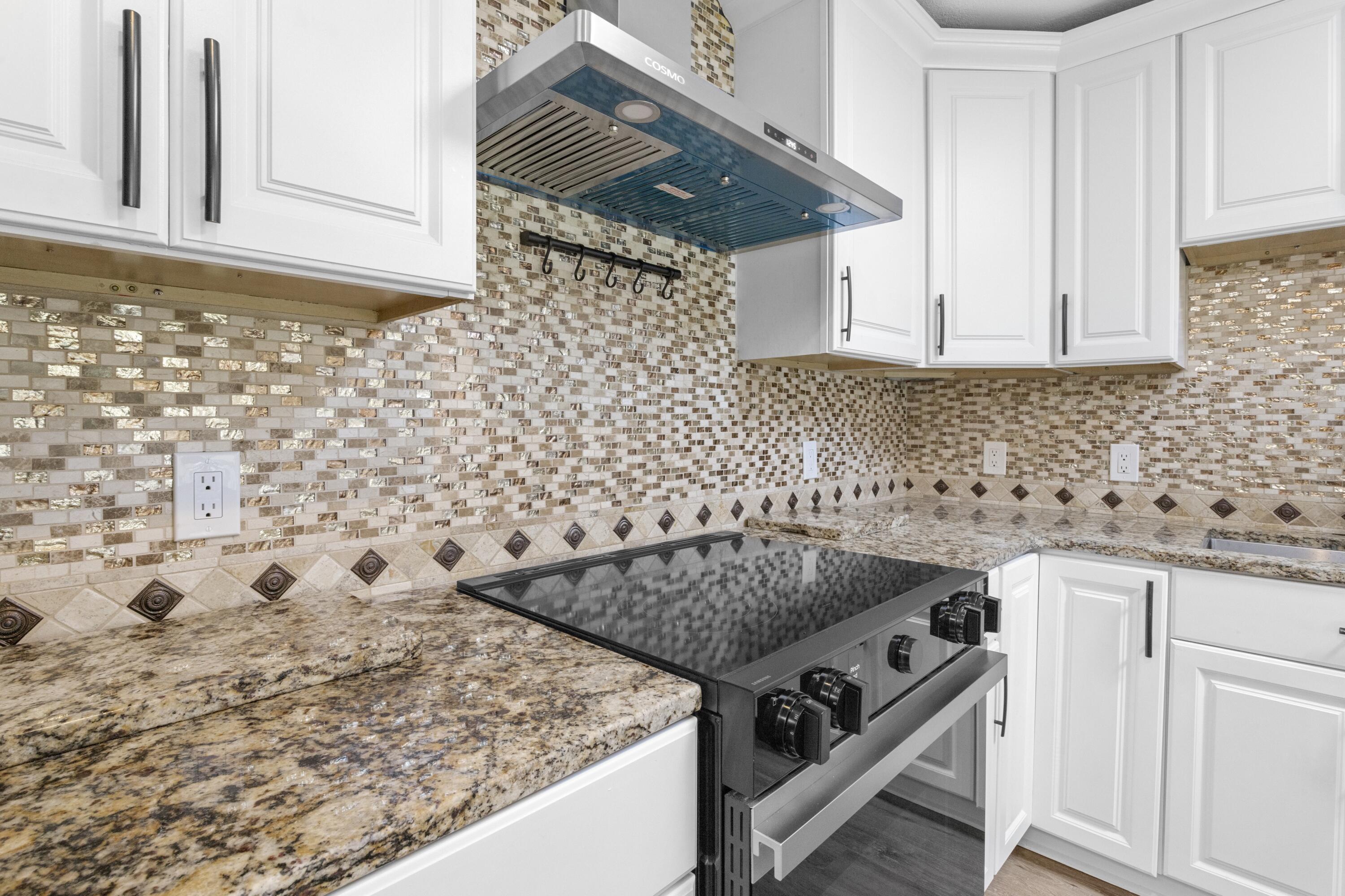 308 Spring Lane Destin, FL 32541 - Photo 10 of 47 a kitchen with granite countertop white cabinets and white appliances