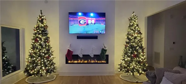 a kitchen with stainless steel appliances kitchen island granite countertop a refrigerator a stove and white cabinets with wooden floor