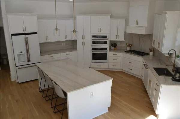 a kitchen with granite countertop white cabinets and stainless steel appliances