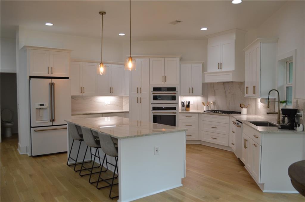 8 Ripplewood Trail Euharlee, GA 30145 - Photo 21 of 90 a kitchen with stainless steel appliances granite countertop a refrigerator a sink dishwasher a stove and white countertops with wooden floor
