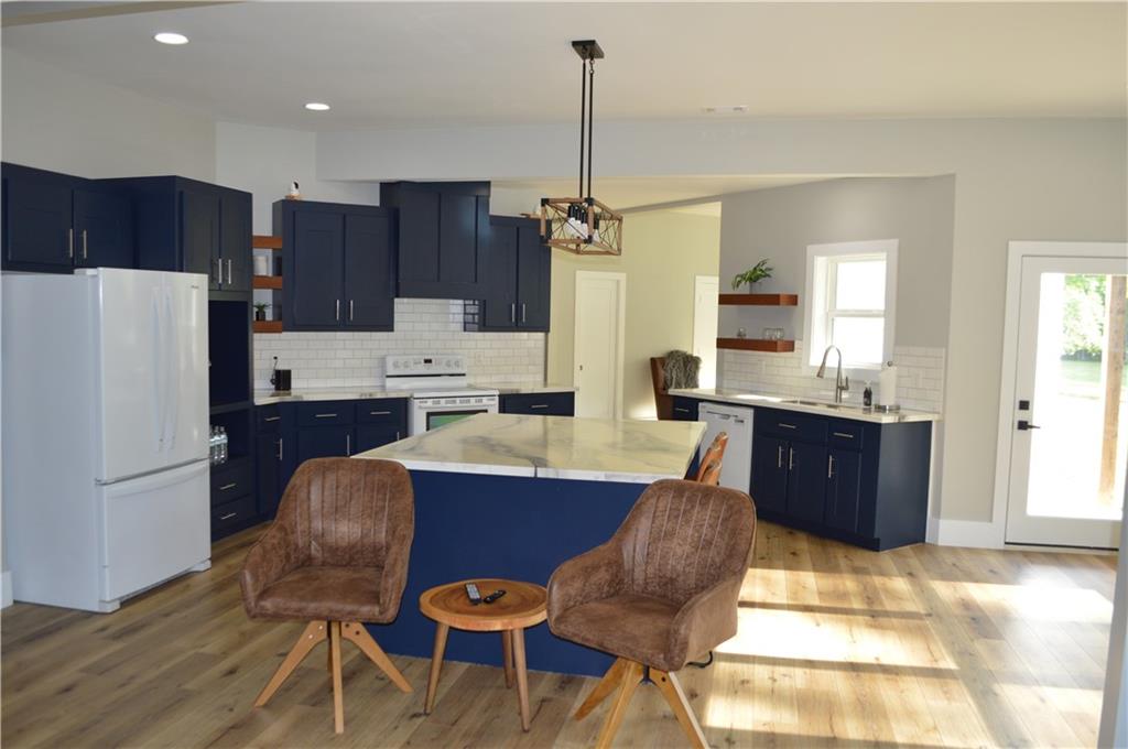 8 Ripplewood Trail Euharlee, GA 30145 - Photo 65 of 90 a kitchen with stainless steel appliances kitchen island granite countertop a refrigerator a stove a sink a dining table and chairs